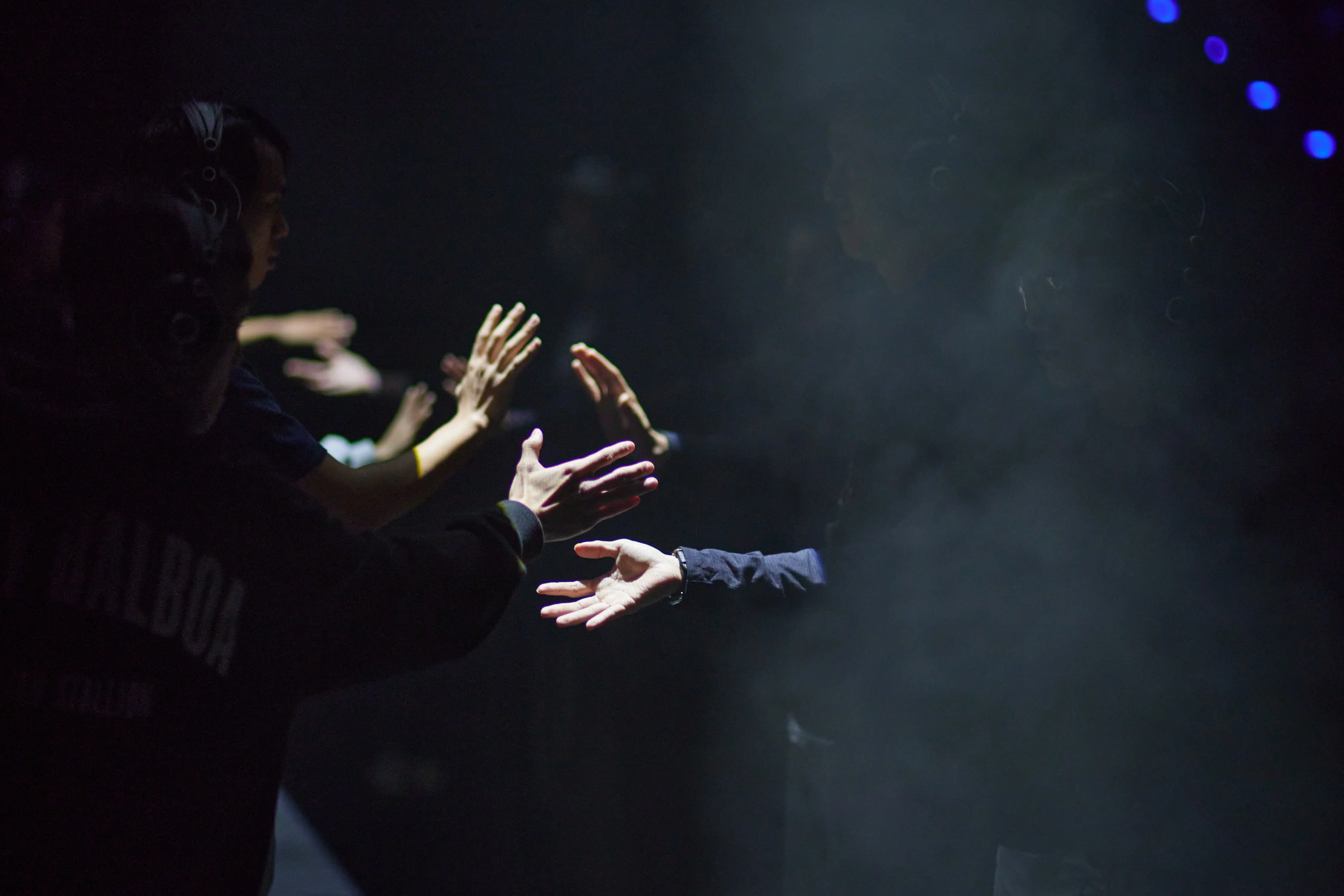 Sur un plateau sombre, on voit seulement les mains des participants, 
          qui semblent dancer