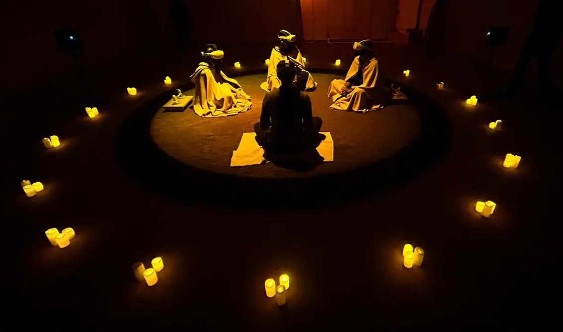 Les participants de l'expérience, assis par terre en cercle, avec leurs 
          oculus, illuminés seulement par des bougies